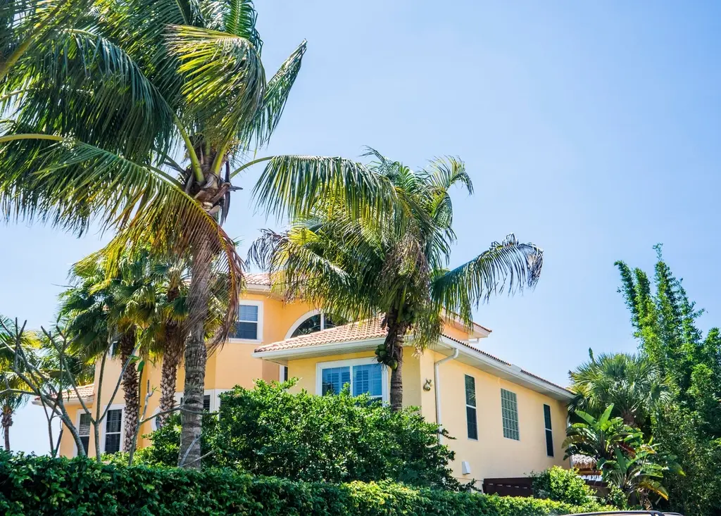 Two-story Florida-style home surrounded by palm trees