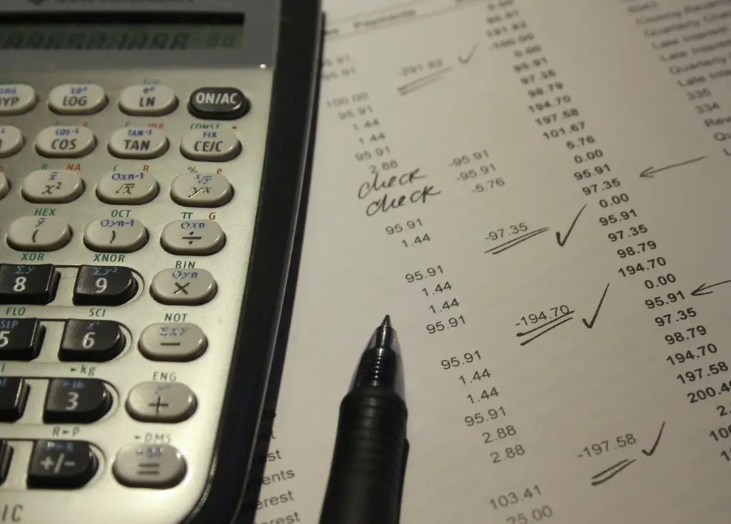 Calculator, pen and printed figures on a desk